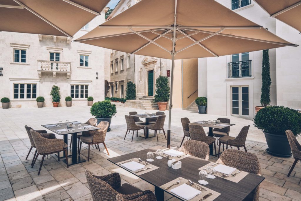 Courtyard terrace with restaurant tables and umbrellas